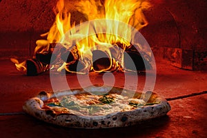 Pizza in wood fired oven with open fire photo