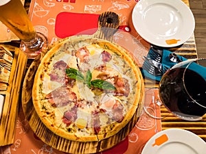 Pizza on a wooden plate. Delicious pizza served on wooden table