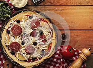 pizza on a wooden table covered in cheese and toppings