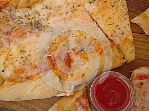 Pizza on wooden table with tomato sauce
