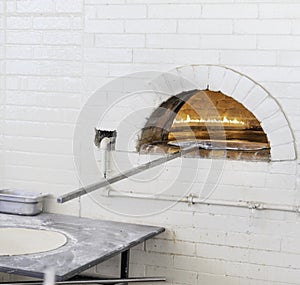 Pizzas or pita bread baking in an open firewood oven