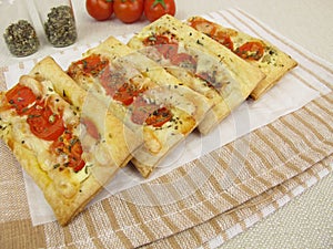 Pizzas from puff pastry with tomato and cheese