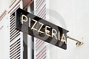 Pizzeria restaurant black sign with white illuminated text