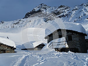 pizzo scalino e baite in pietra innevate, alta Valtellina