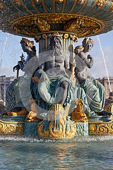 Place de la Concorde fountain statues with golden details in a sunny day in Paris, France