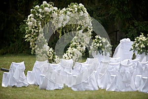 Place decorated for the wedding ceremony with heart arch from white flowers. Outdoors setup