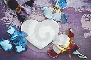 place for a heart-shaped text on a wooden background with multi-colored iris flowers of different varieties. Blue and