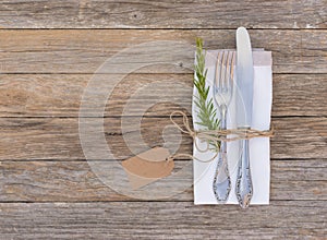 Place setting with cutlery and napkin on wooden table background