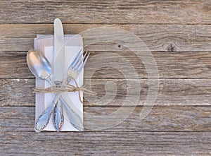 Place setting with elegant cutlery and napkin on wooden table background