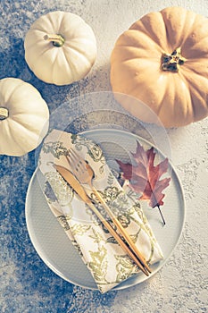 Place setting for Thanksgiving in vintage style with pumpkins and autumn leaf