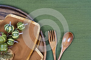 Place setting with wooden plate, fork and spoon