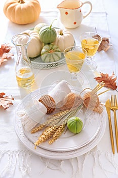 Place settings for Thanksgiving with pumpkins and apple wine