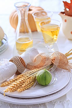 Place settings for Thanksgiving with pumpkins and apple wine