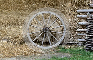 Place with stacks of hay cubes and rustic wooden wheels of old cart