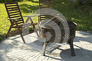 Place to fry meat. Metal grill. Cooking meat. Two chairs