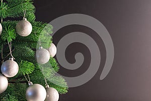 Place for your text, beautiful black background with a decorated Christmas tree decorated with silver balls, copy space.
