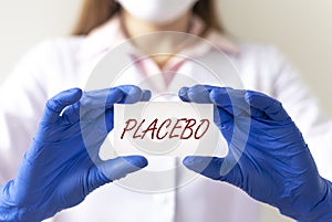 Placebo word, concept inscription. female doctor hands with paper close up
