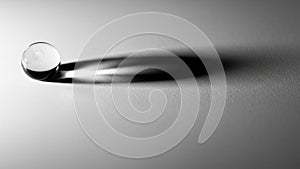 Is placed on a textured white surface casting a long soft shadow