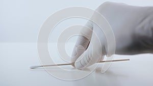 Placeing a swab for covid testing on a white surface.