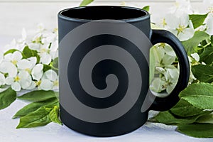 Placeit-Black coffee mug mockup with spring apple blossom photo