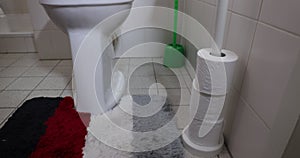 Placement of five rolls of toilet paper in a plastic holder standing in the bathroom