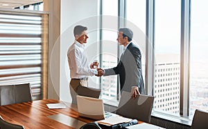 The places well go...two businessmen shaking hands in a corporate office.