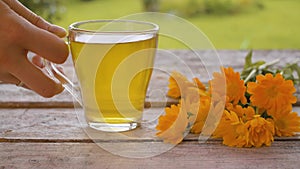 Placing down cup of calendula tea