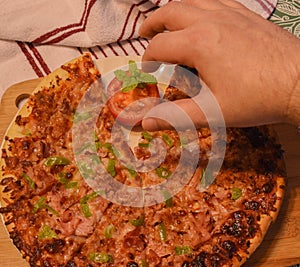 Placing half a tomato with peppermint next to the pizza started photo