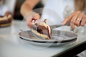 Placing a piece of delicious vegan chocolate cake on a plate