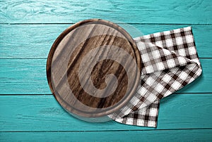 Plaid tablecloth and cutting board for pizza on blue wooden table. Wood background. Top view and mock up