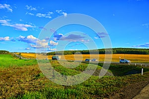 Plain autumn landscape. A motorway with cars passing along it passes by agricultural fields.