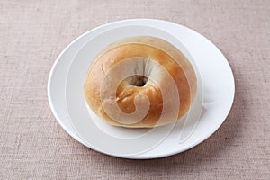 plain bagel bread on plate isolated on table cloth