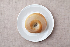 plain bagel bread on plate isolated on table cloth