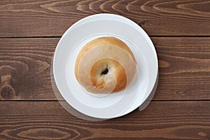 plain bagel bread on plate isolated on wooden table