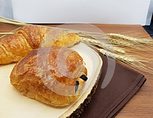 Plain and Chocolate croissant on wooden board and rustic background