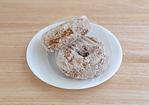 Plain coconut flake donuts on a white plate