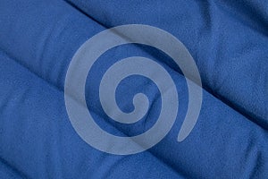 Plain dark blue fabric made of artificial materials as wallpaper close-up
