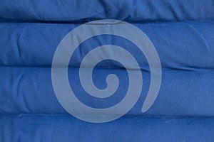 Plain dark blue fabric made of artificial materials as wallpaper close-up