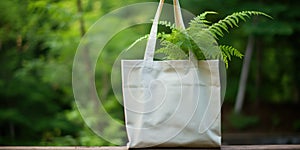 Plain rag eco bag against a background of green bush , concept of Eco-friendly fashion