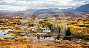 Plain thingvellir national park in reykjavik enters to the iceland golden circle. countryside with river, church, houses