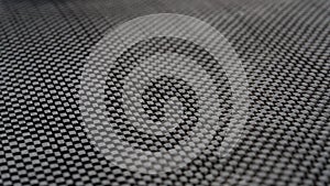 Plain weave woven Black carbon fiber composite material background close up view