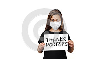 Plain white background with space for text. Asian lady wearing face mask for protection against coronavirus. Half body view young