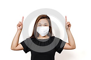 Plain white background with space for text. Asian lady wearing face mask for protection against coronavirus. Half body view young