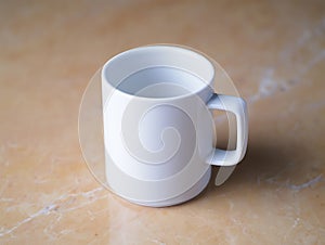 Plain white ceramic mug on a textured wooden surface