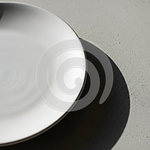 A plain white ceramic plate partially