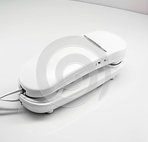 Plain white corded home telephone.