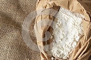 Plain white flour in a brown paper bag on hessian sack cloth. Eco friendly biodegradable packaging