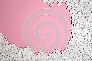 Plain white jigsaw puzzle frame on pink color, background, abstract backdrop