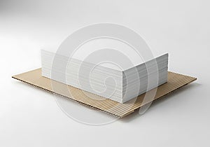 A plain white rectangular box sits on a brown cardboard base isolated on a clean white surface