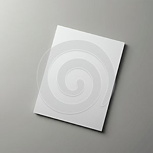 A plain, white sheet of paper is centrally positioned on a smooth, gray background.